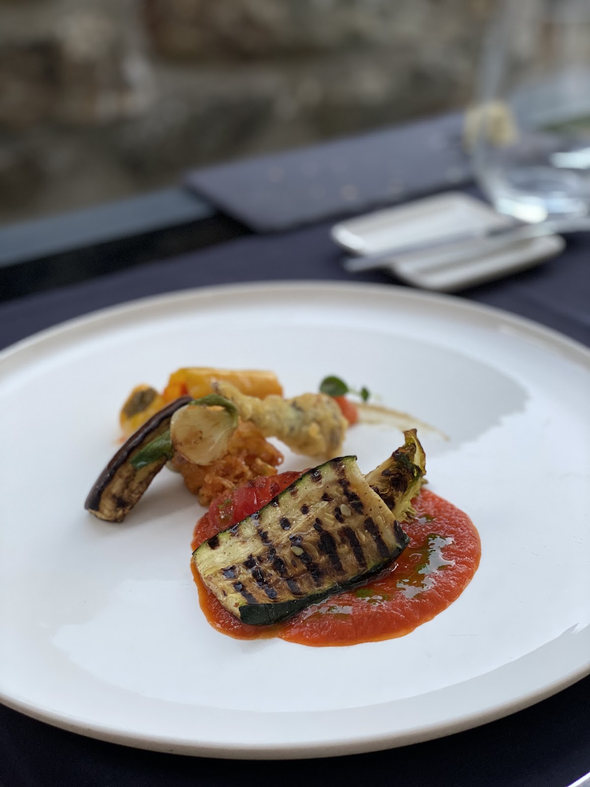 Plated vegetarian dish with grilled vegetables and tomato coulis